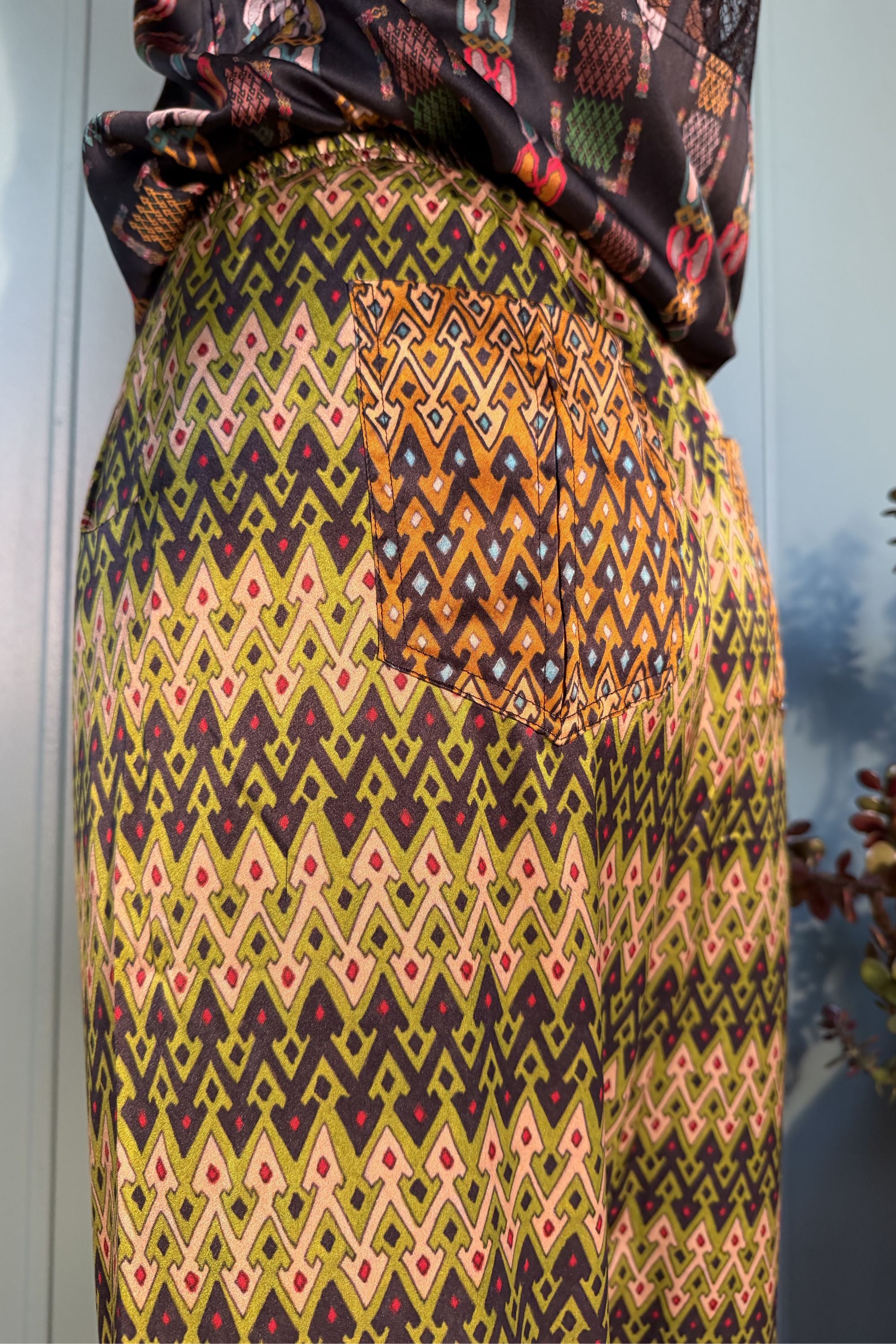 Close-up of the contrasting back pocket on Zahara Sporrof Green silk trousers