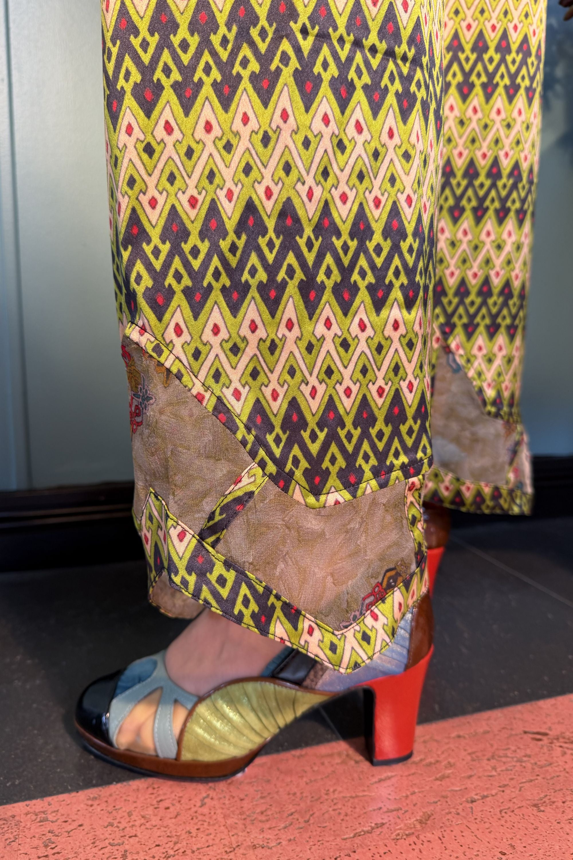 Close-up of semi-sheer Esme Light silk panels at the hems of Zahara Sporrof Green trousers