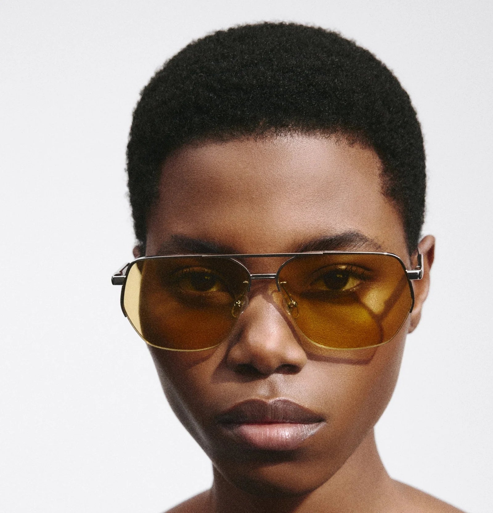 Model wearing Jacquemus Aviador sunglasses in silver and yellow, front view