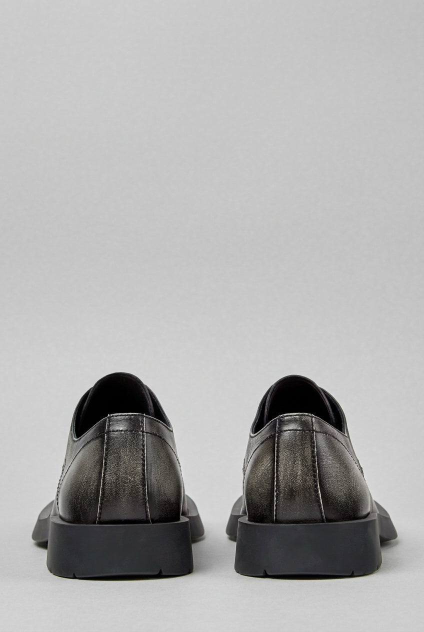 Rear view of CamperLab MIL 1978 black and white leather lace-up shoes