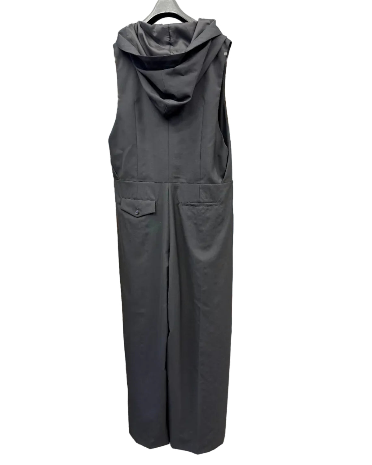 Back view of noir kei ninomiya black wool jumpsuit showing hood and contrasting back pockets