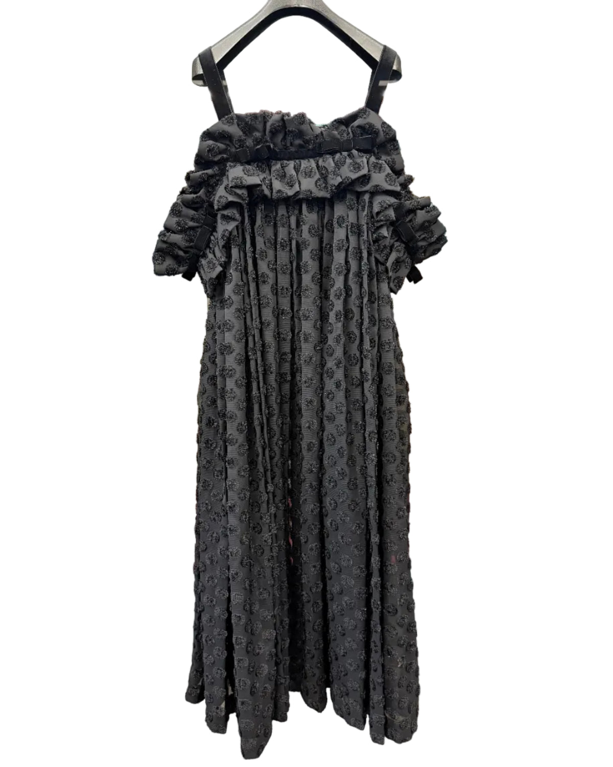 Back view of noir kei ninomiya black pleated dress showing textured dotted fabric and ruffled upper detail
