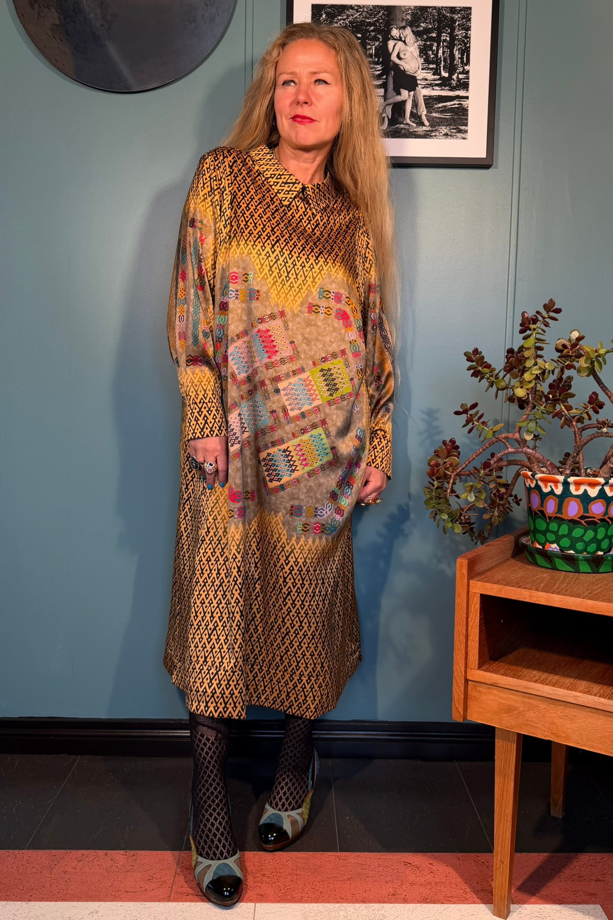 Full-length view of Kron by Kronkron Esme Gold dress with fluid A-line shape and expressive print by Hugrún and Magni