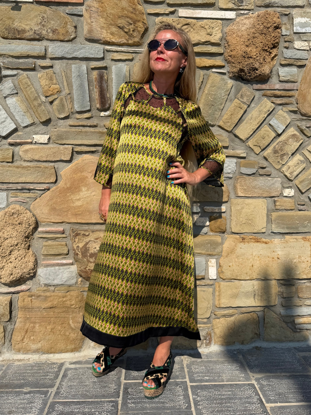 Full-length outdoor view of Jacqueline Sporrof Green silk dress showing the relaxed midi silhouette and dark hem border