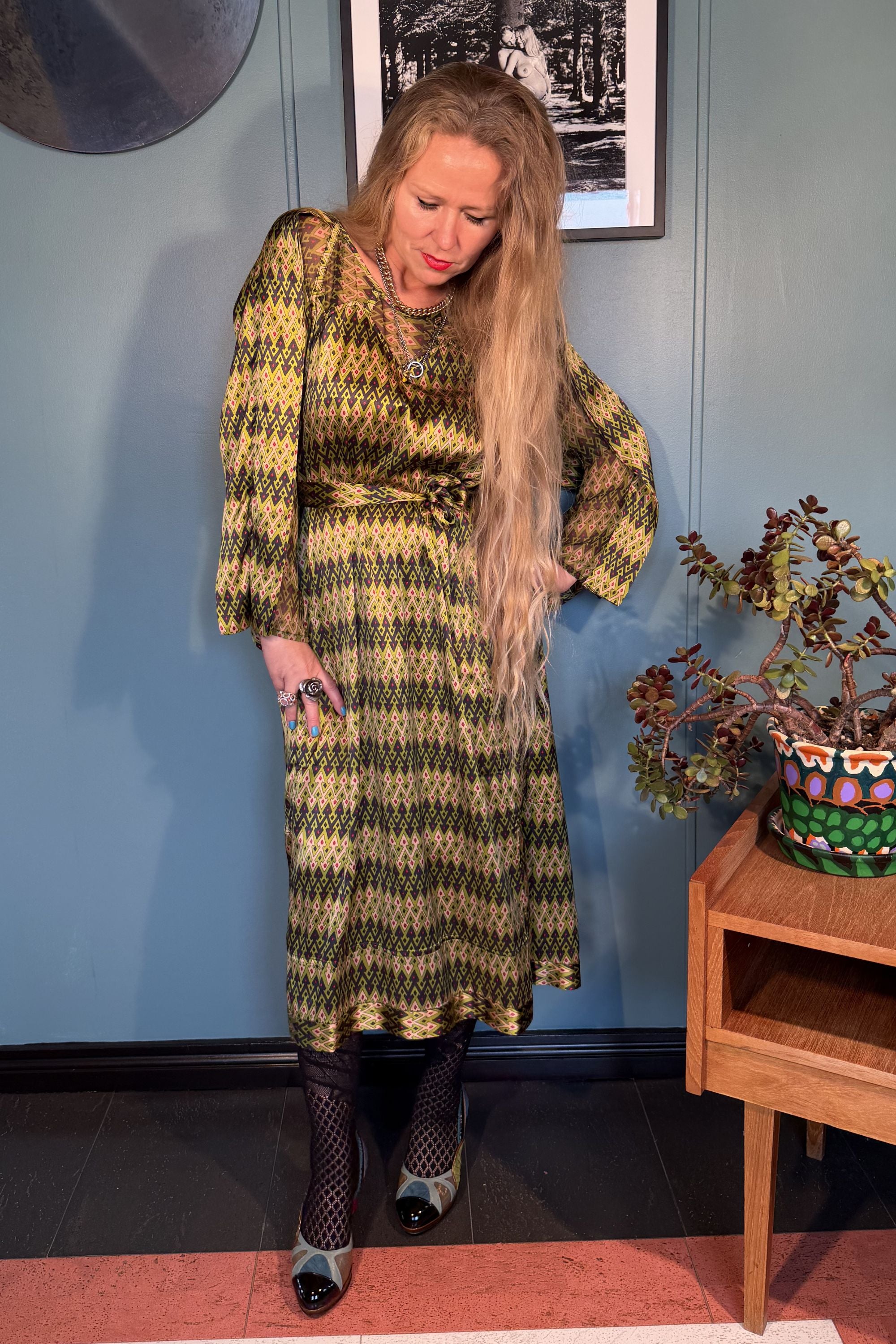Woman wearing the Josephine silk satin dress in Sporrof Green print by Kron by Kronkron, front view with waist belt
