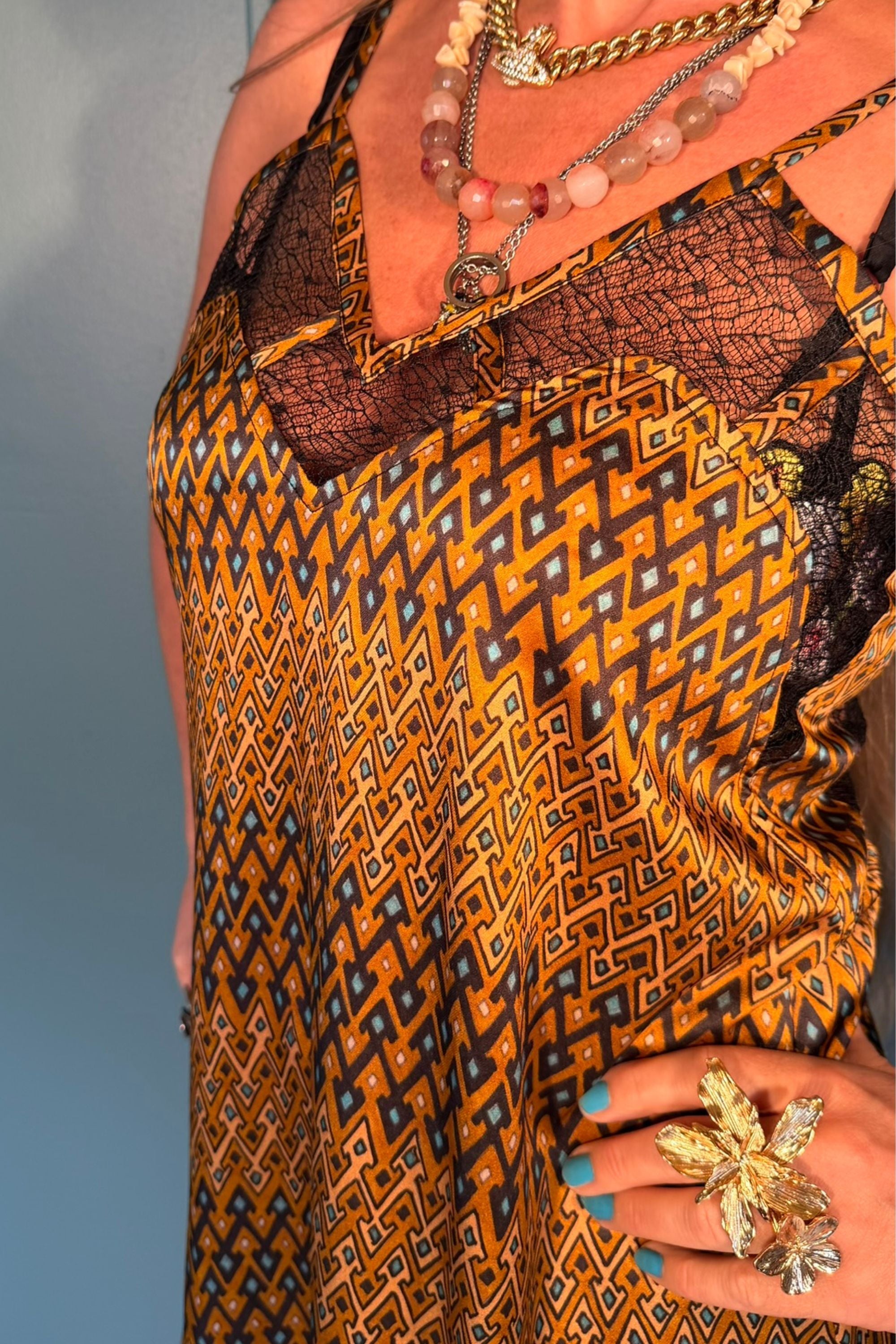 Close-up of Norma Lang Sporrof Gold silk dress showing black lace neckline and geometric print