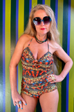 Kron by Kronkron Pam Long Bikini Top in Daggdís print worn with matching bottoms in front of a striped green and blue wall