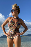Kron by Kronkron Pam Long Bikini Top in Það sem ég sé print worn on the beach with matching bikini bottoms under a bright blue sky