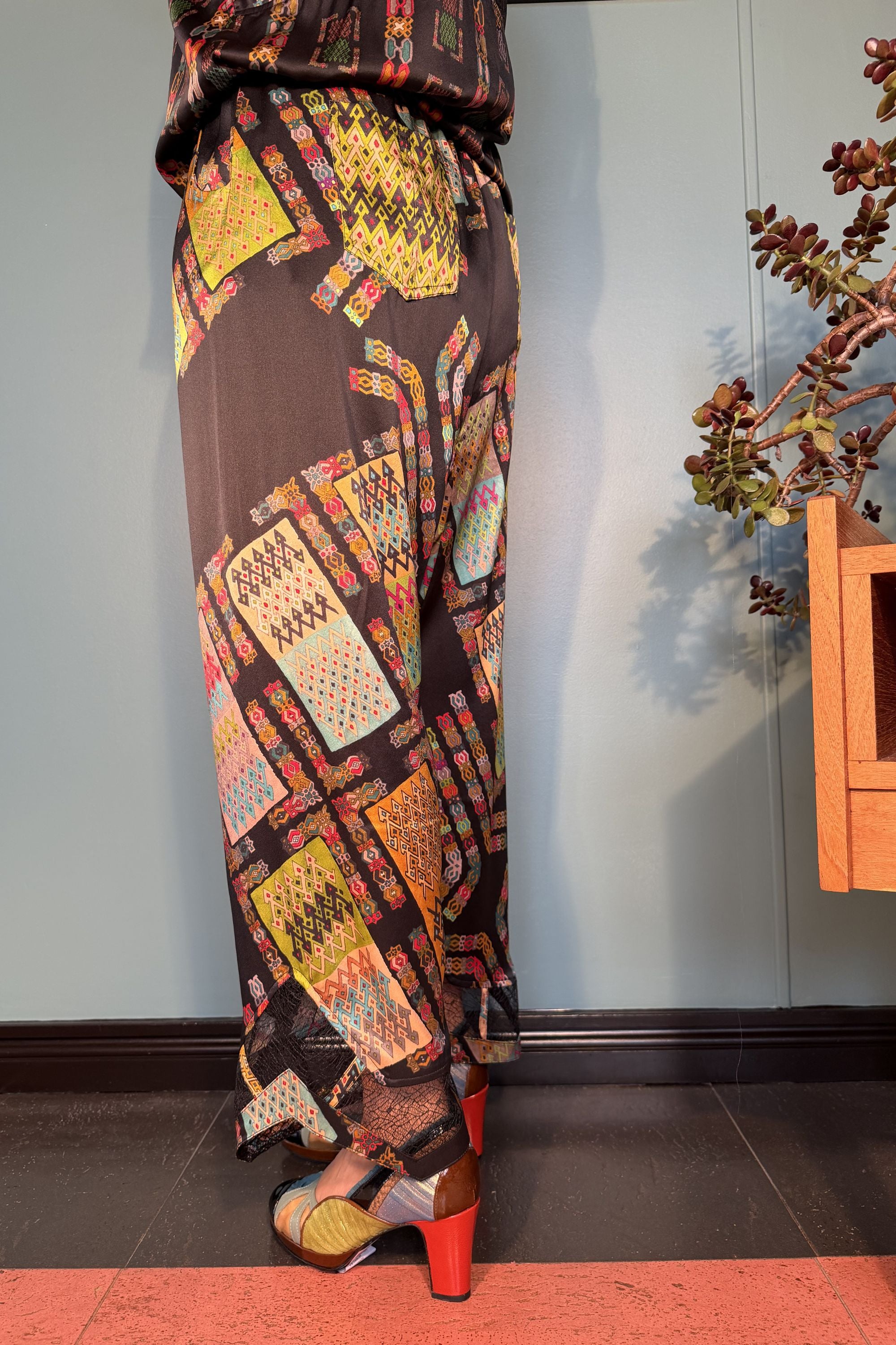 Side and back view of Zahara silk trousers showing the relaxed fit and colourful Harly Black print