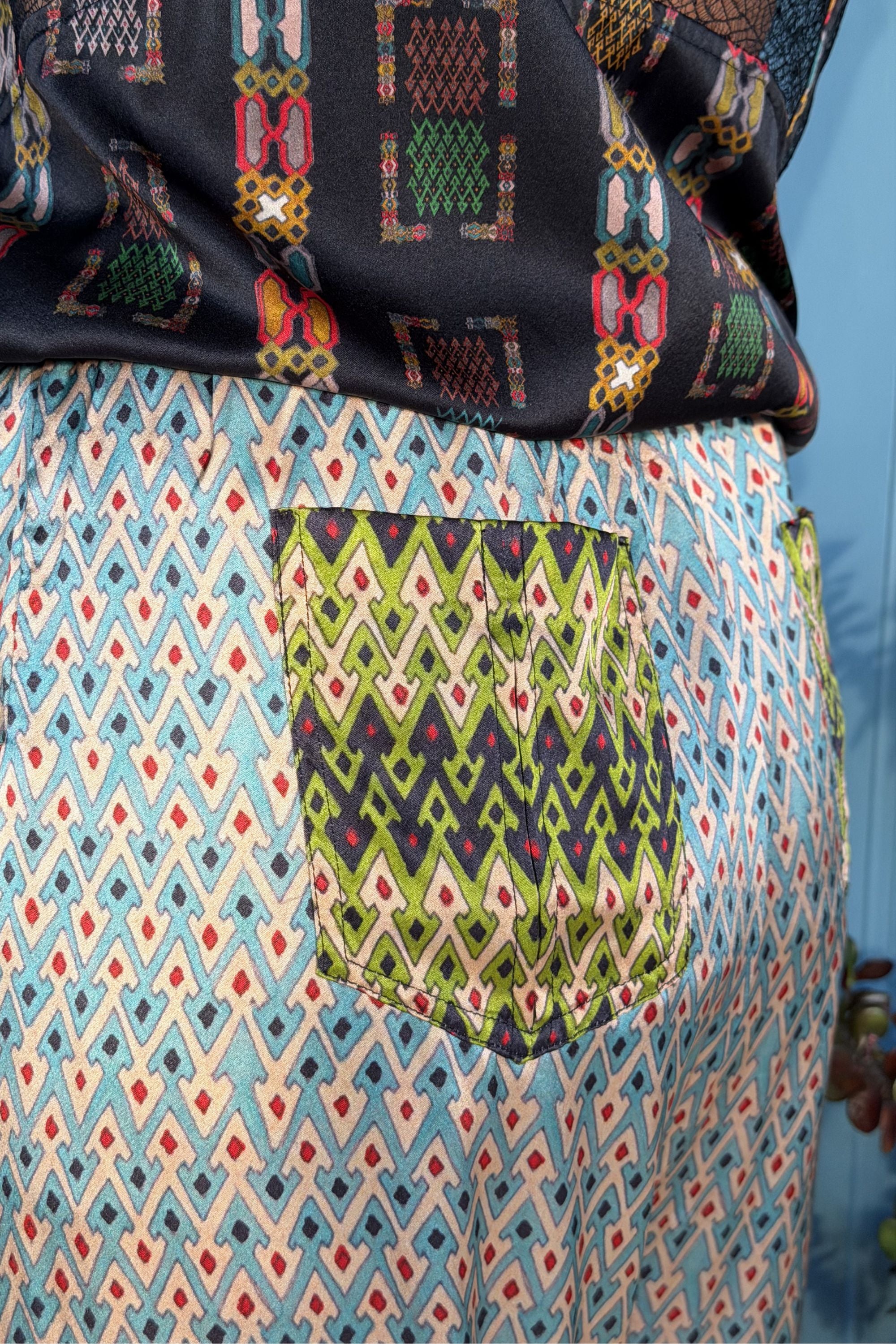 Close-up of the back patch pocket and contrasting prints on Zahara Sporrof Blue silk trousers