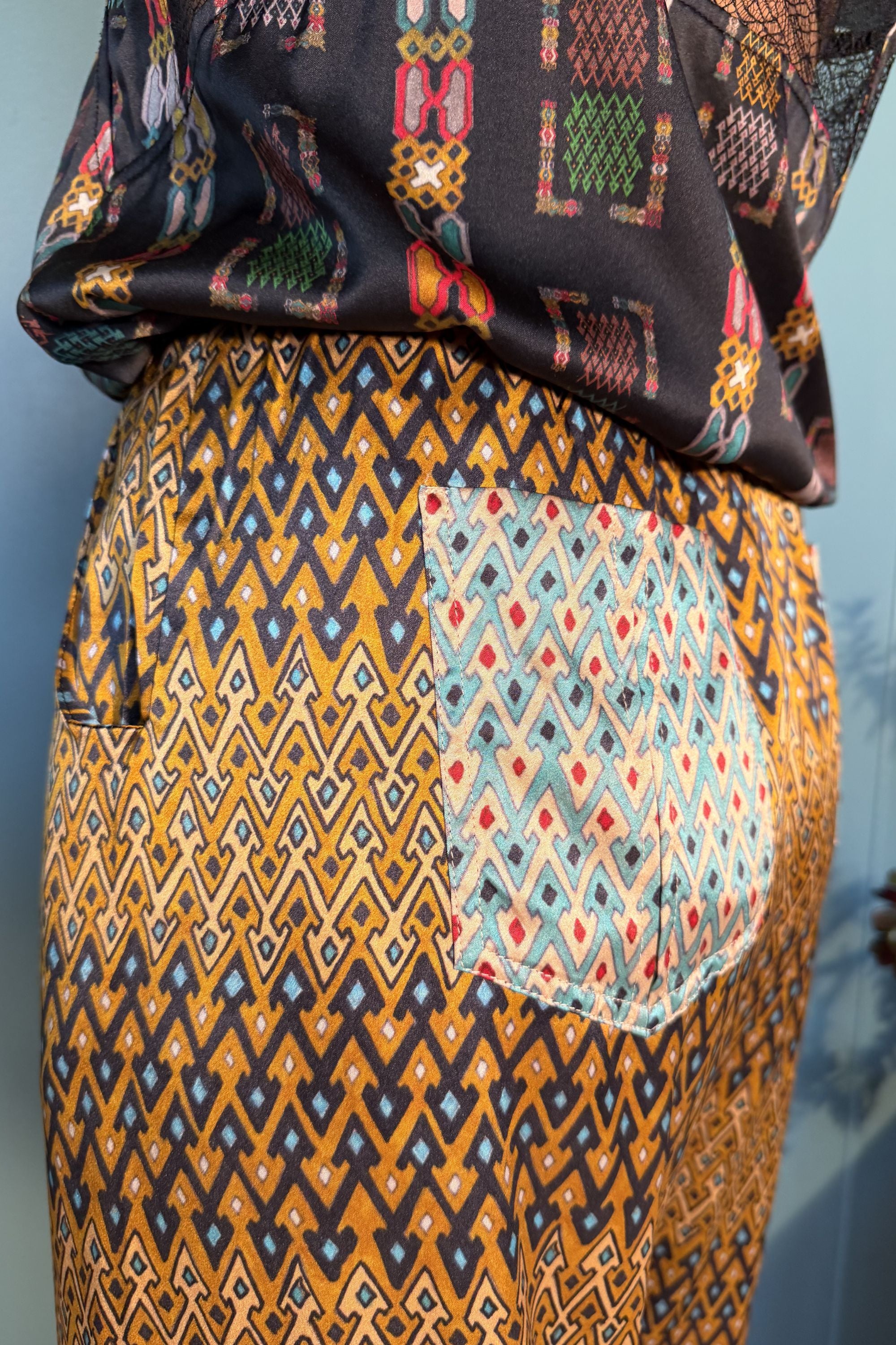 Close-up of contrasting back patch pocket on Zahara Sporrof Brown silk trousers
