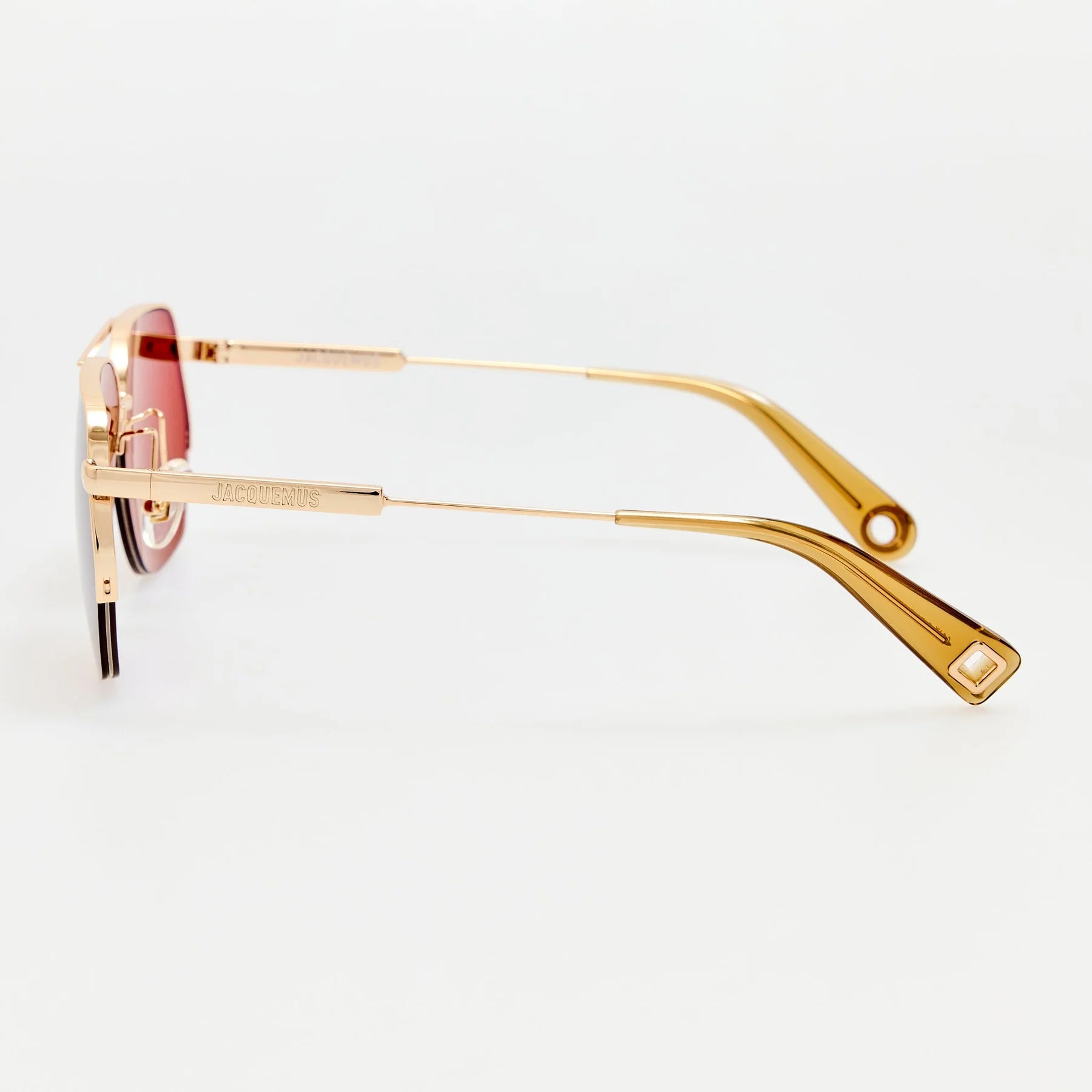 Side view of Jacquemus Aviador sunglasses showing light gold temples and logo detail