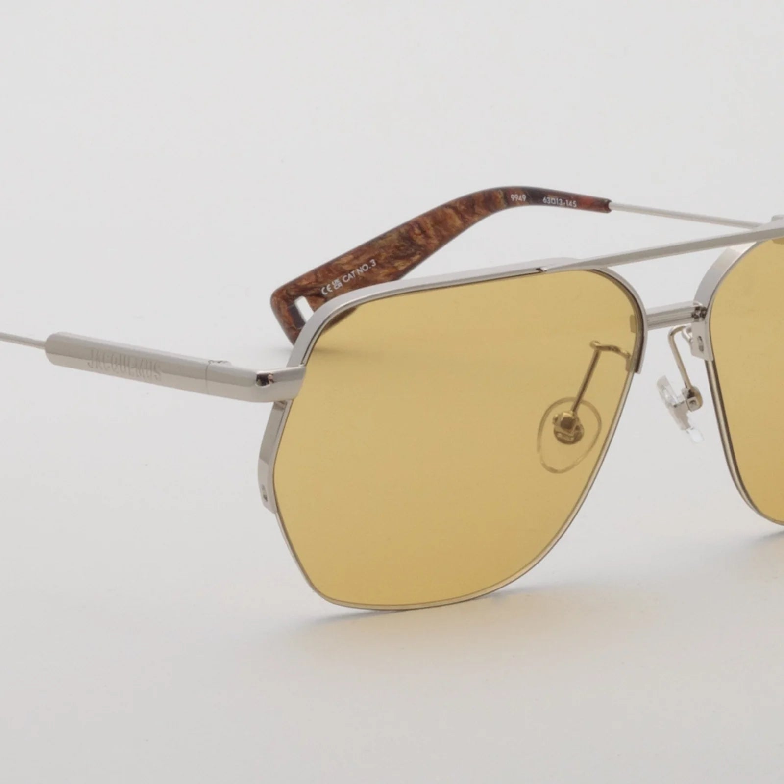 Close-up of Jacquemus Aviador silver frame, yellow lens and adjustable nose pad