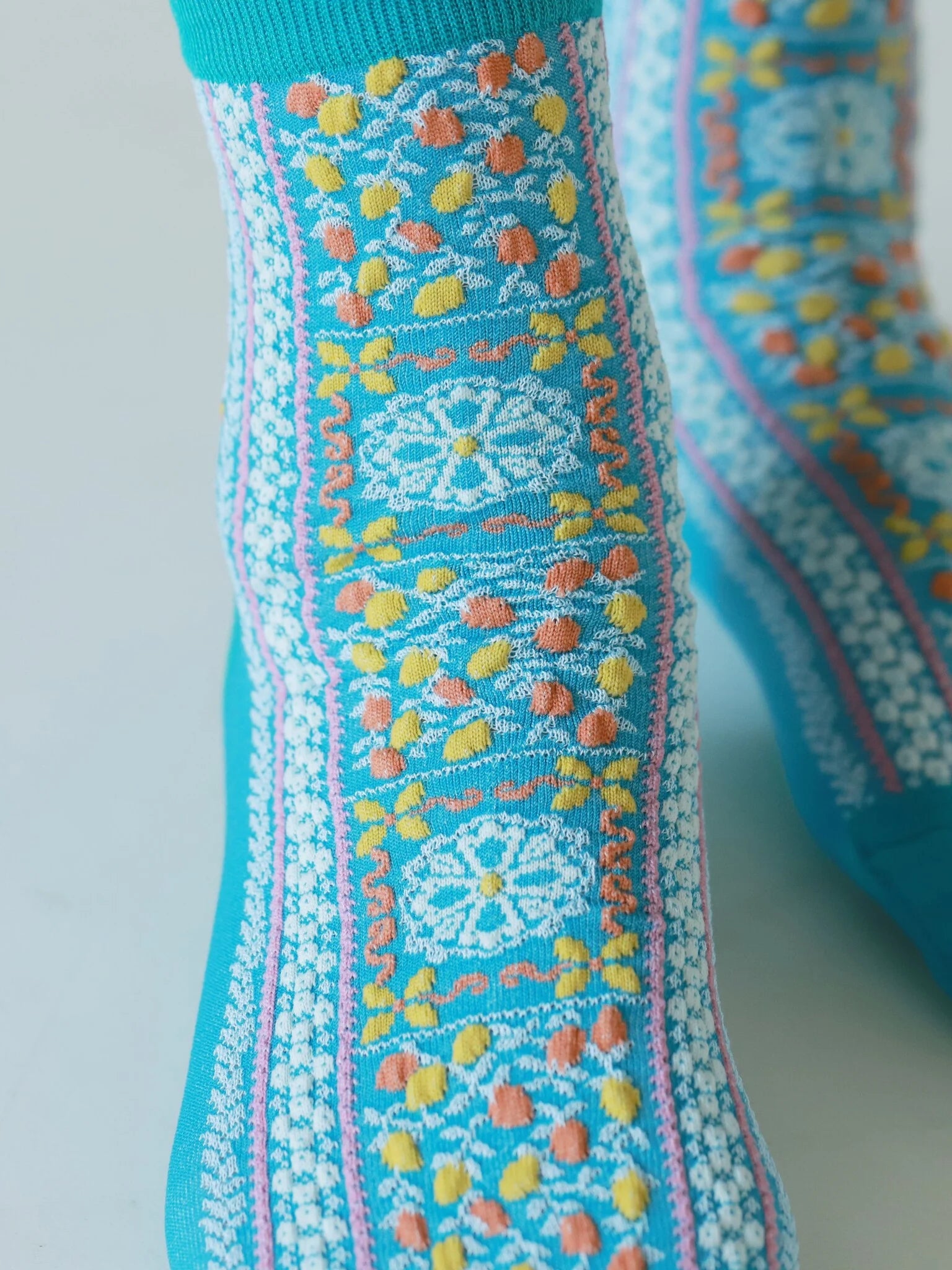 Tabio Sicilian Pattern Low Crew Socks in blue with multicolour Sicilian-inspired pattern worn on the foot