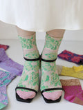 Tabio Float Flowers Low Crew Socks in pink with green floral pattern worn with black heeled sandals